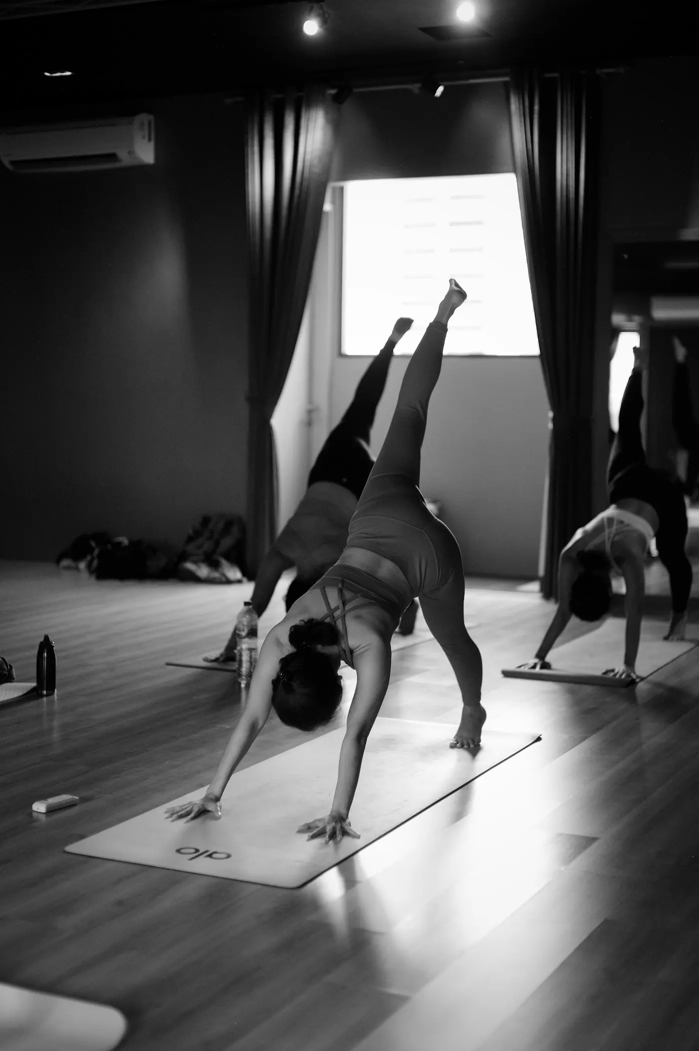 A group on mats in the small room, mid-morning light through the windows.
