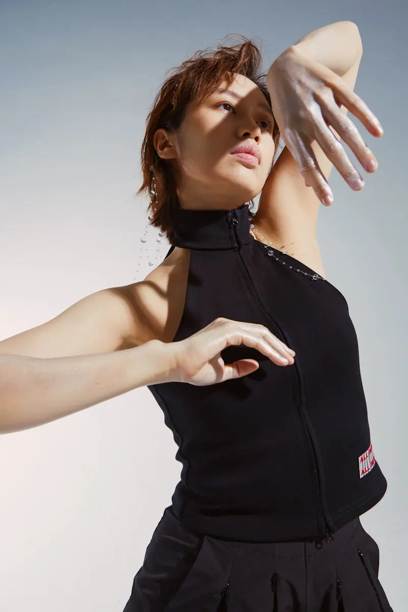 Anya Bila, founder and movement director, mid-gesture with one arm across her face.